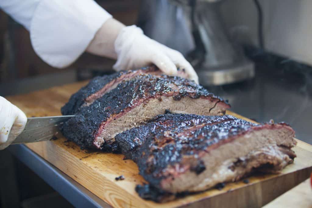 large piece of smoked brisket meat on a wooden board