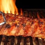 Pork Ribs Roasted On The Hot Flaming Charcoal Grill