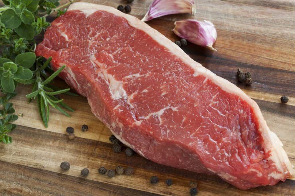 raw sirloin steak with herbs