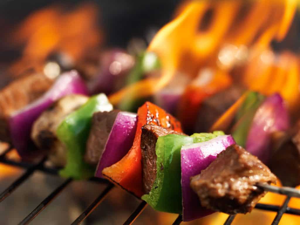 steak shish kabobs on grill with flames