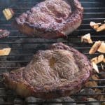 Steaks With Wood Chips On A Charcoal Grill