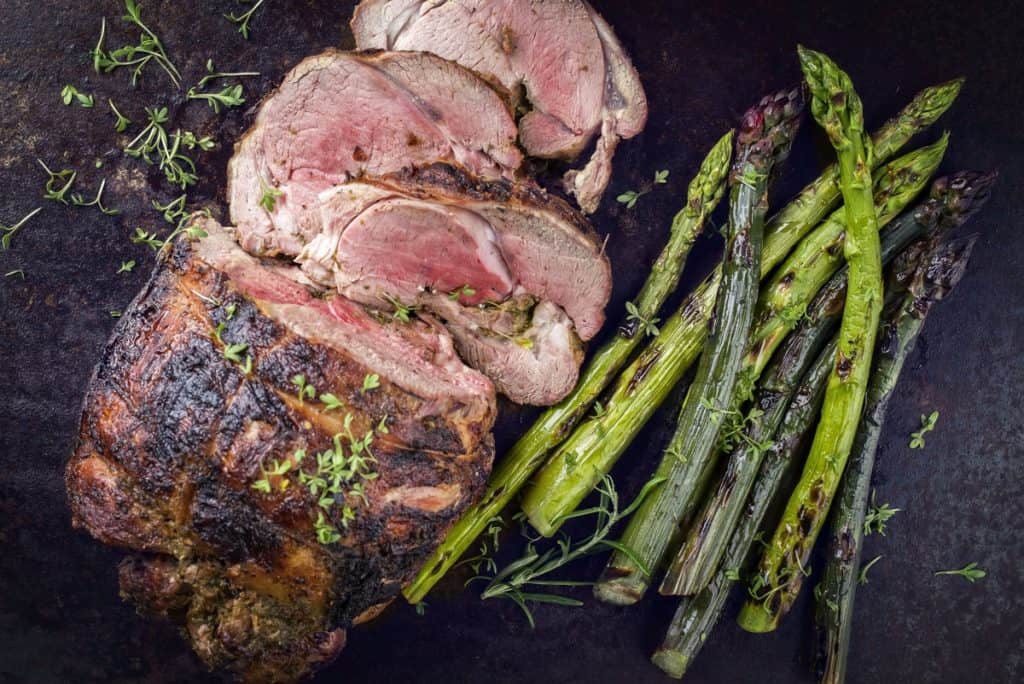 traditional barbecue lamb roast with green asparagus