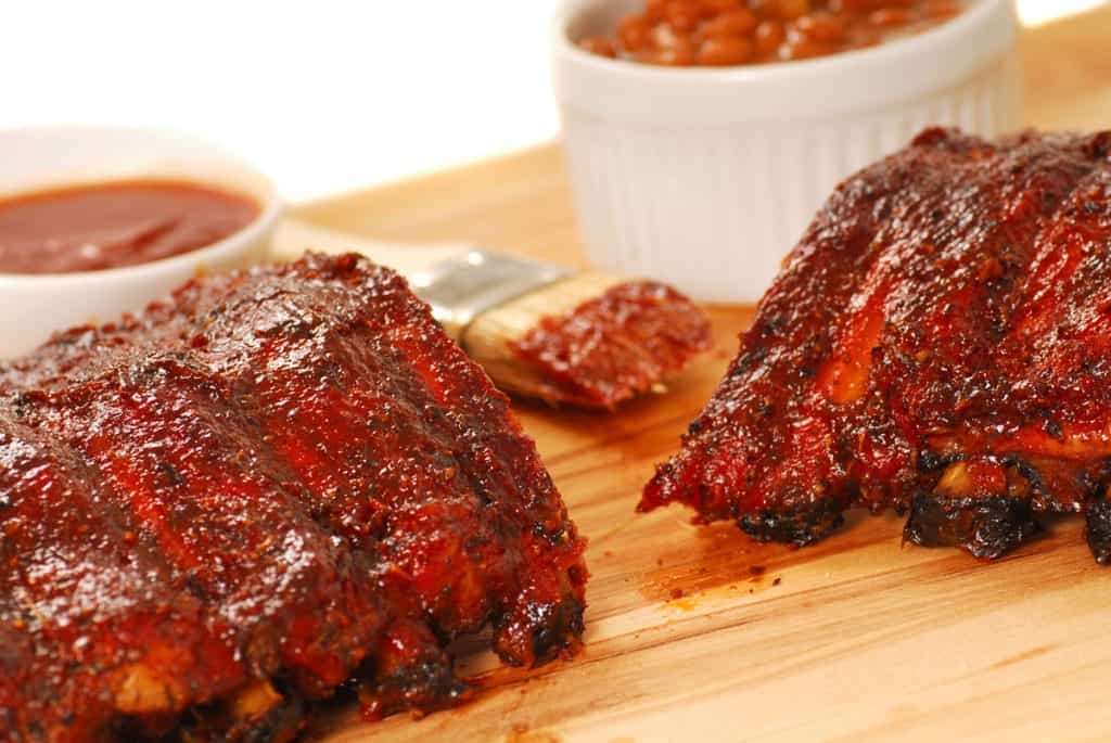 Slab of BBQ spare ribs with beans and dipping sauce