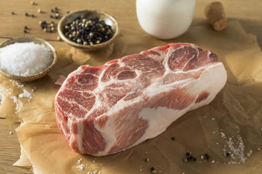 raw pork shoulder with salt and pepper