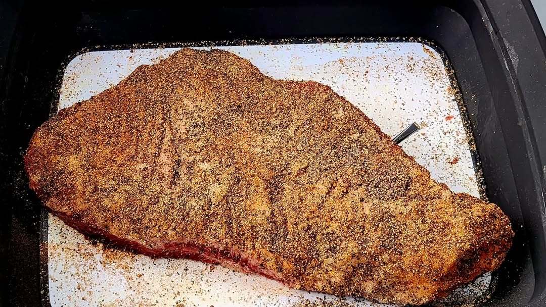 Sliced smoked brisket on cutting board with knife.