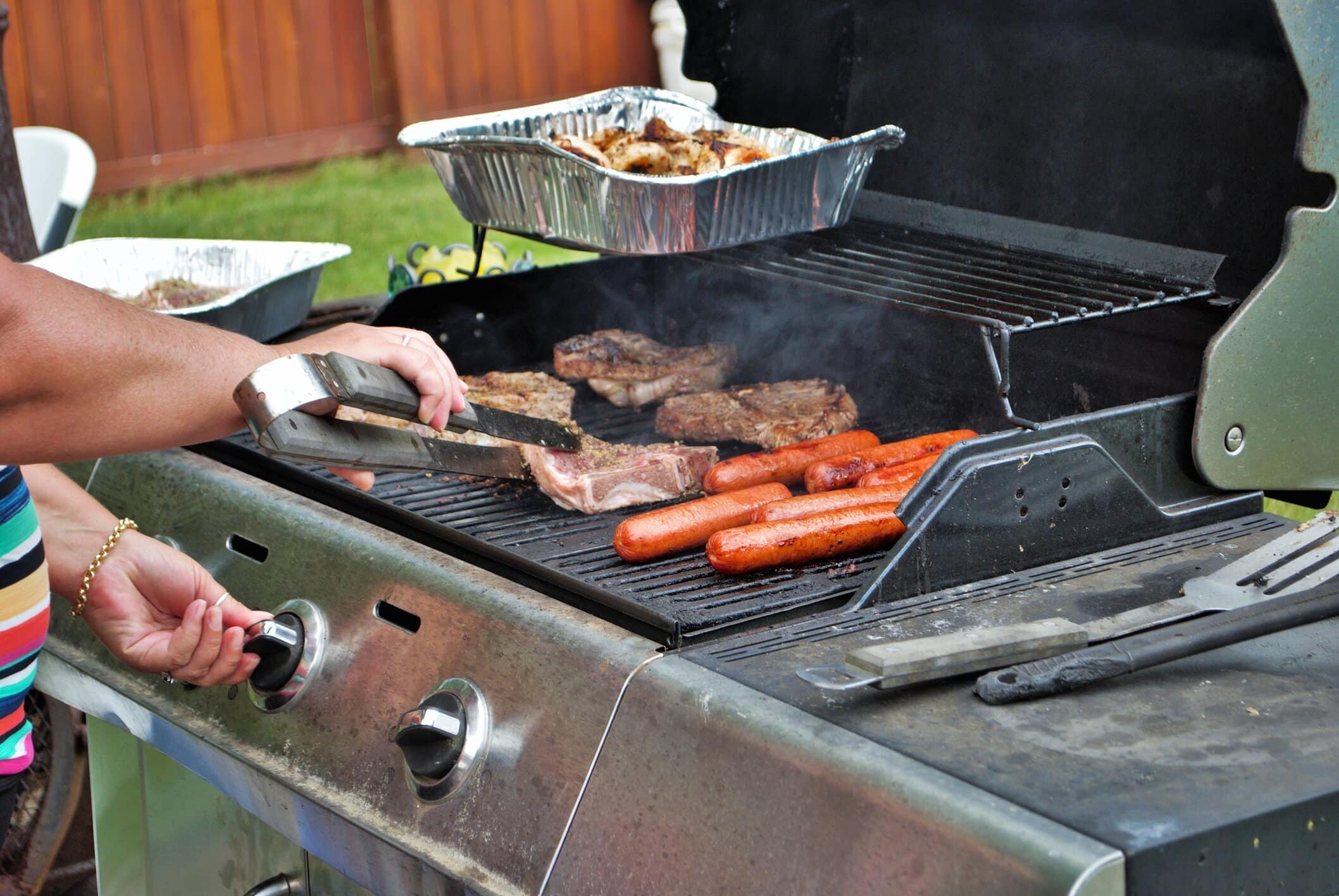 Backyard grill cookout with food on barbecue.