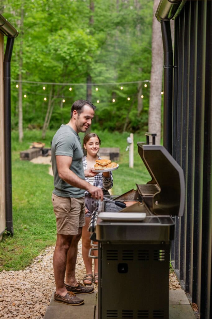 Dad and daughter grilling meat.