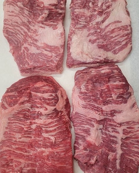 Raw trimmed beef brisket cuts with marbling.
