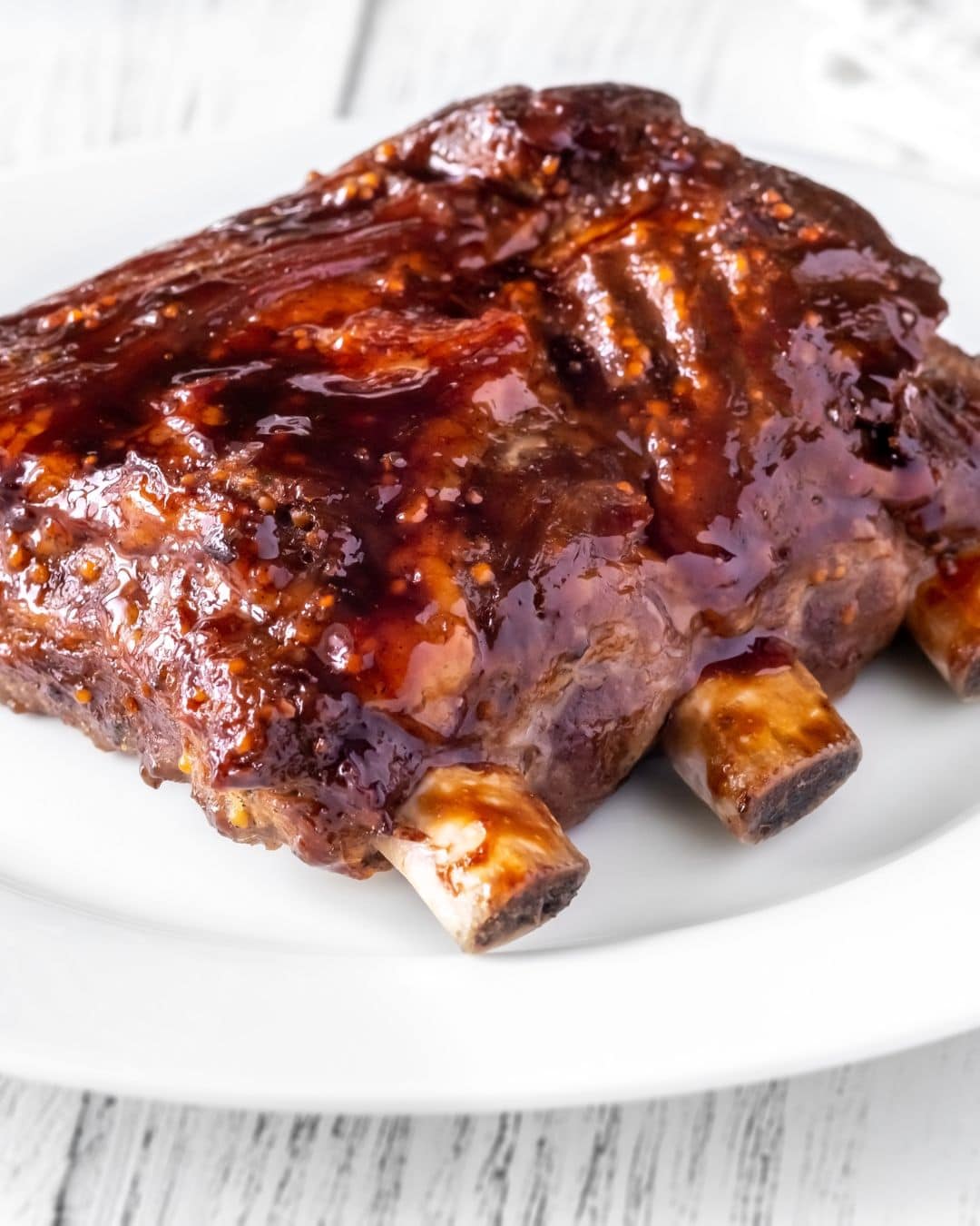 Grilled pork ribs in a white plate.