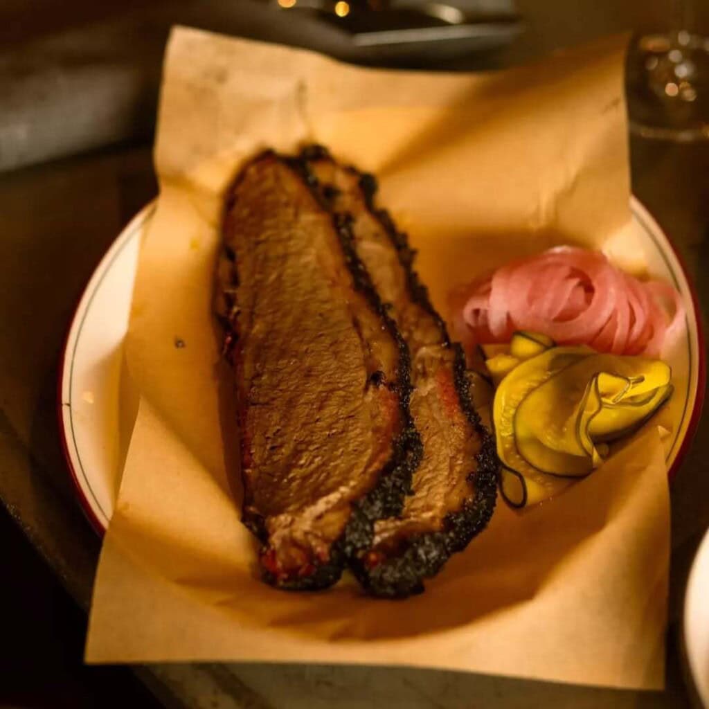 Smoked brisket slices with pickles and onions.