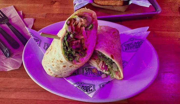Turkey club wrap for lunch loaded with fresh veggies, onions, and savory fillings.