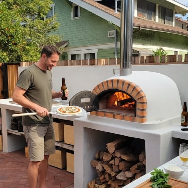 Turn Your Backyard Into A Pizzeria: 17 Outdoor Kitchen With Pizza Oven Ideas 19 Man Cooking Pizza In Pizza Oven