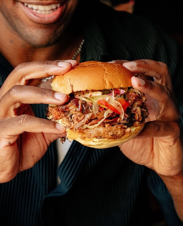 Man Eating A Big Pulled Pork Sandwich