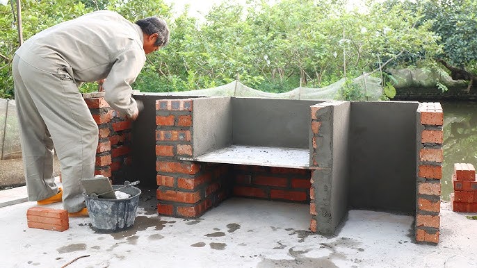 Man Building A Brick Charcoal Grill