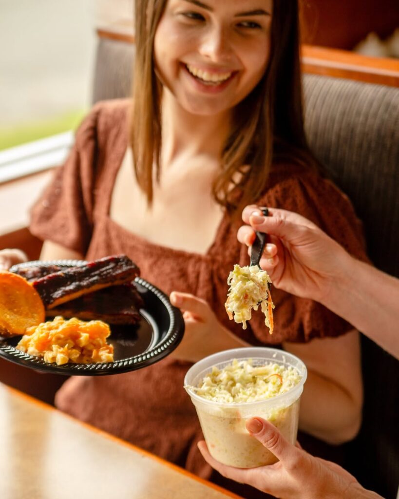 Woman Smiling Eating Bbq And Side Dish