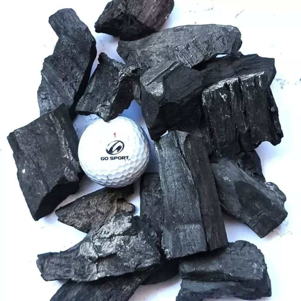 Golf Ball Among Charcoal Lumps