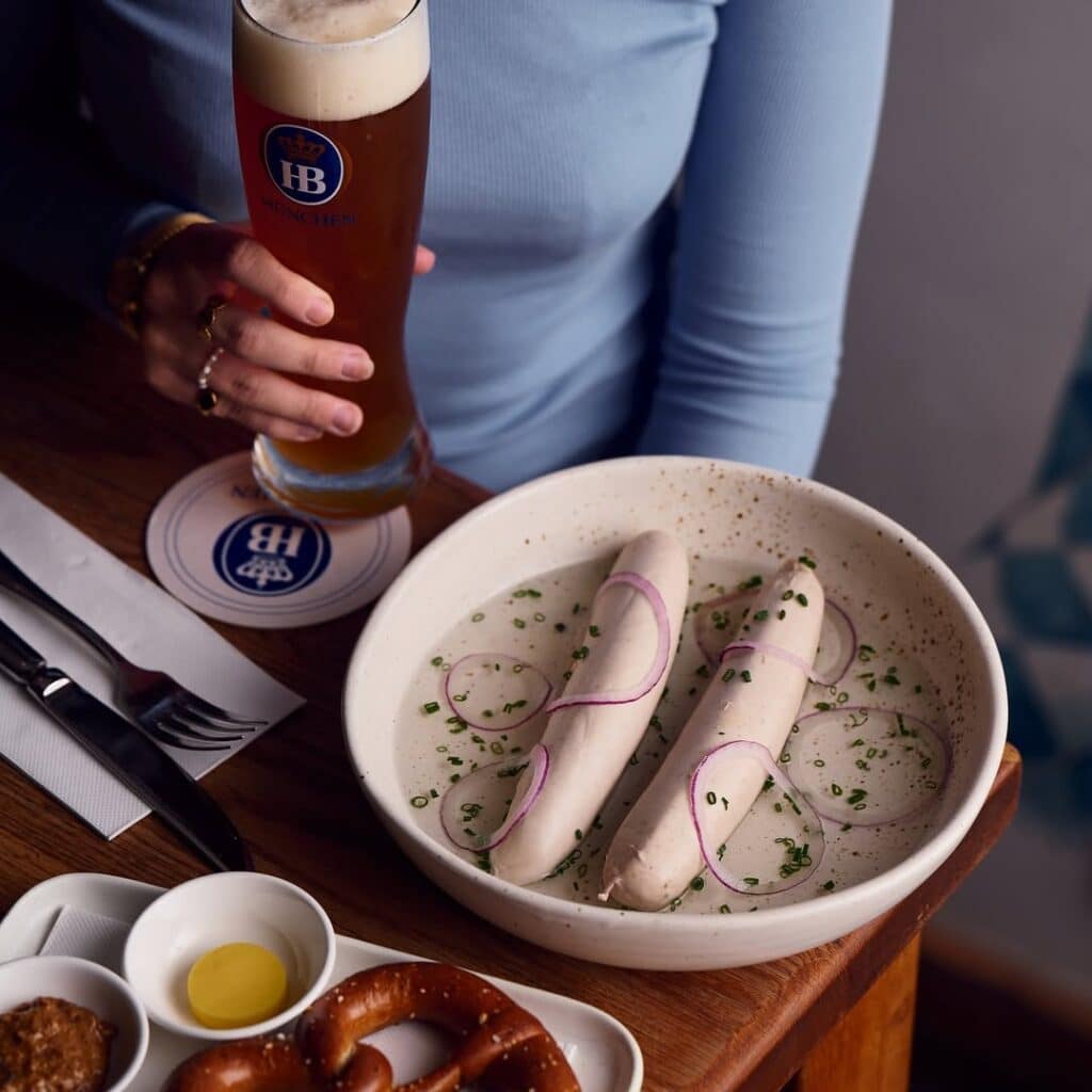 Woman Eating Wurst And Drinking German Beer