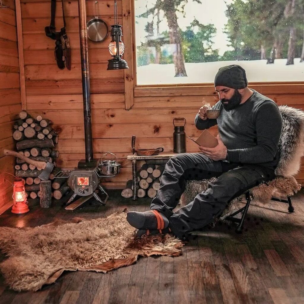 A Hunter In His Cabin Drinking Coffee By The Fireplace