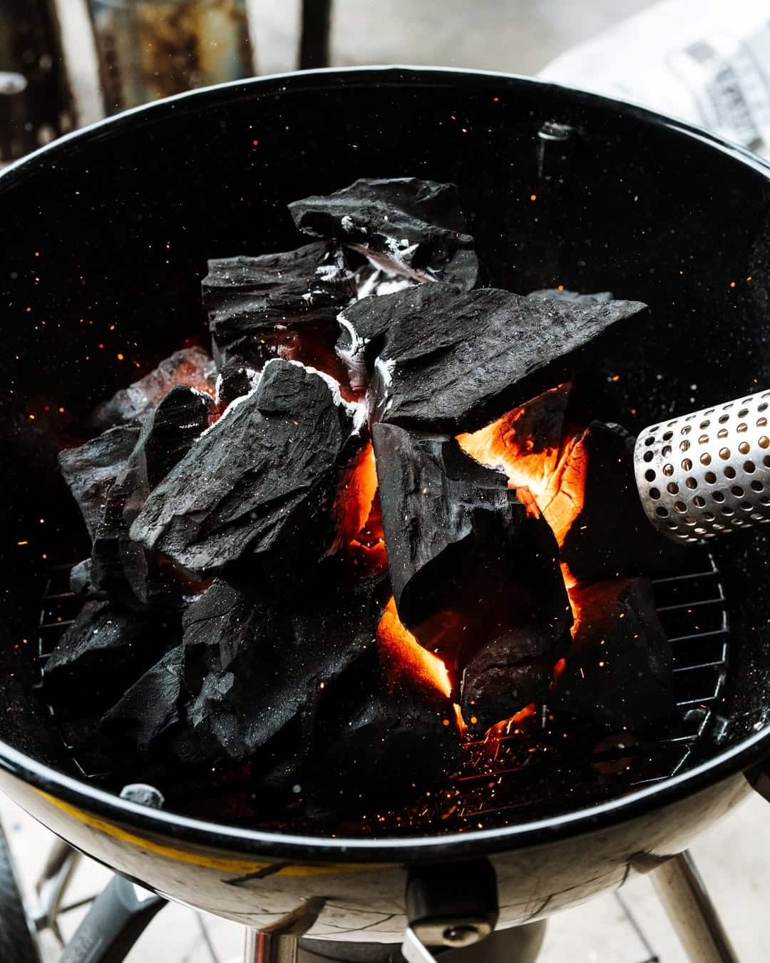 lump charcoal being ignited in a charcoal grill
