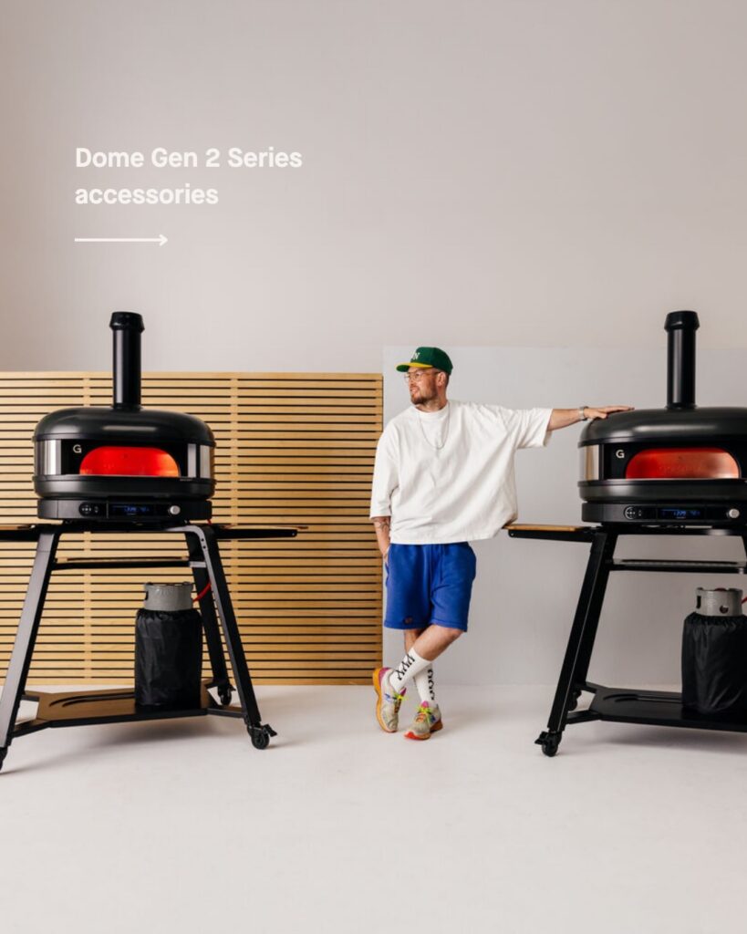 Man Standing Next To Pizza Ovens