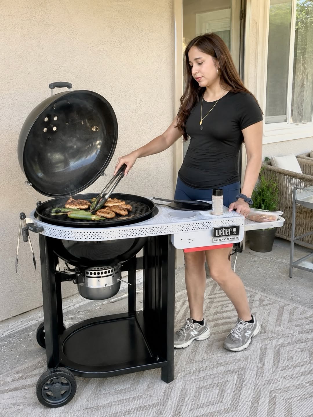 Woman Grilling Food On A Gas Grill With Prep Table
