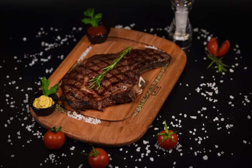 Coffee-Crusted Tomahawk Ribeye: How To Get A Steakhouse Sear On Your Backyard Grill 3 Tomahawk Ribeye Steak On A Wooden Board