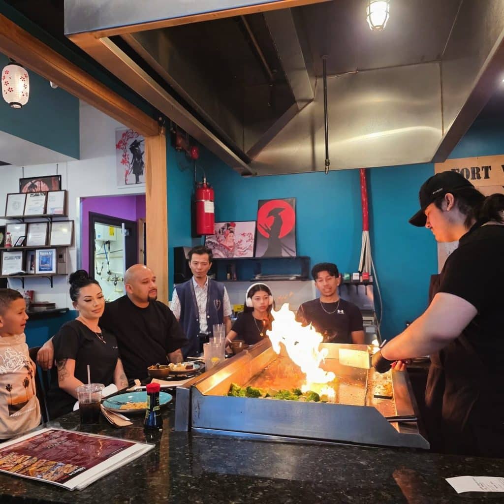 Chef Entertains And Prepares Food For Guests On Hibachi Grill