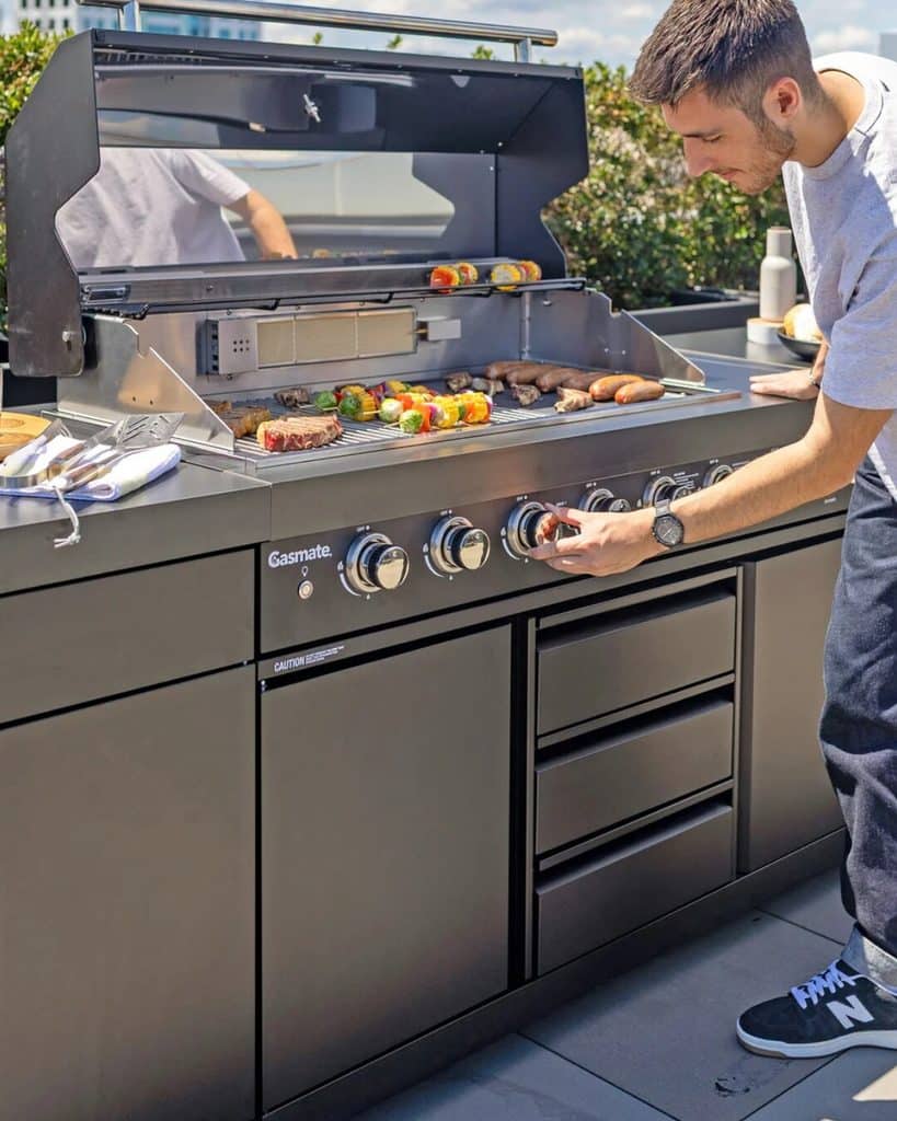 Man Cooking Food On A Large Gas Grill