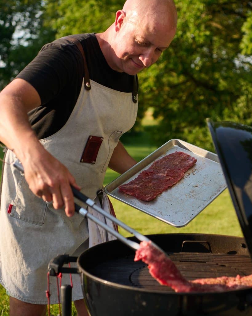 Pitmaster Laying Raw Meat For Bbq